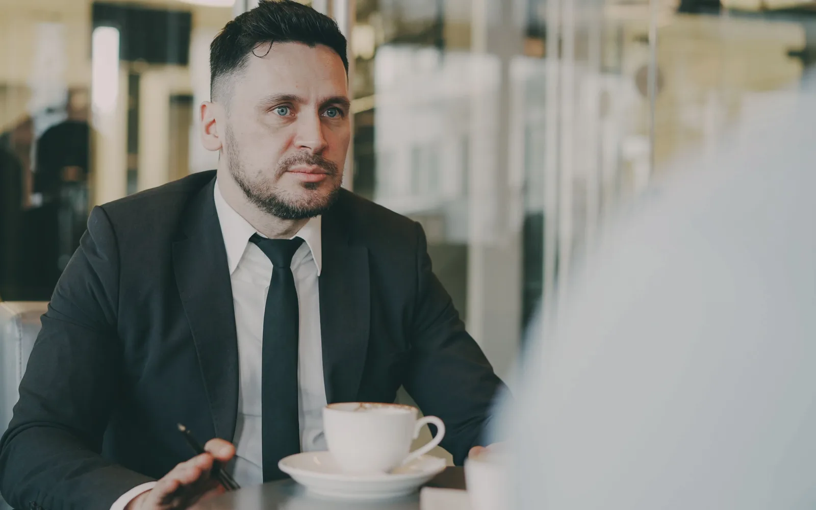 Un rendez-vous client autour d’un café dans un lieu moderne